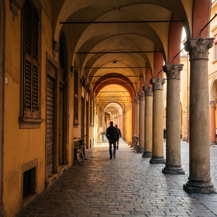Galerie d'arcades voûtées d'un centre historique italien, à la lumière de fin de journée