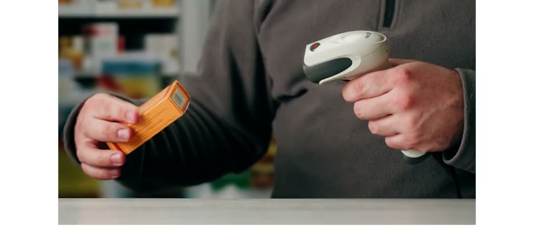 Un pharmacien scanne une boîte au comptoir, vidéo en boucle du cockpit Nexum Pro